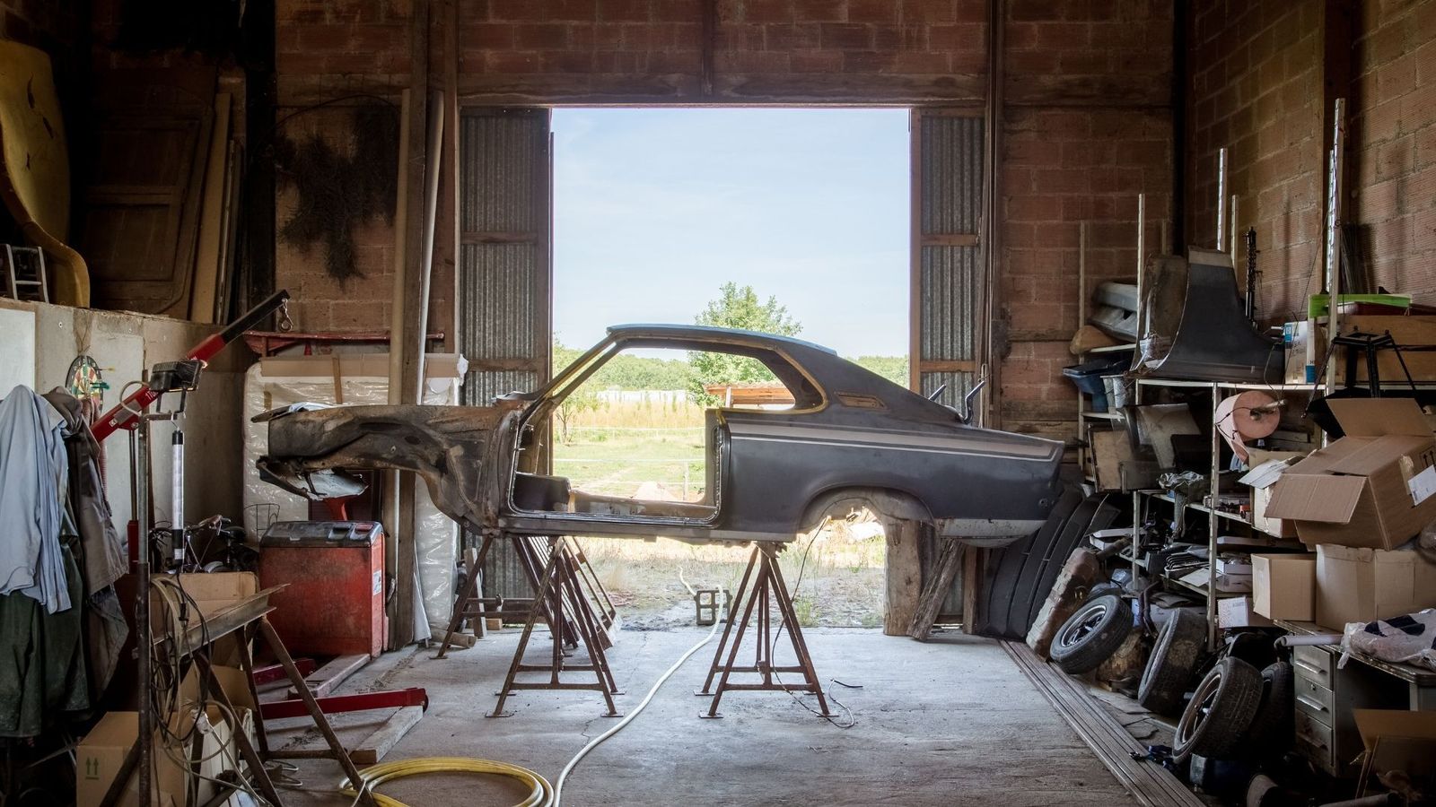 Classic car project shell in a rustic workshop