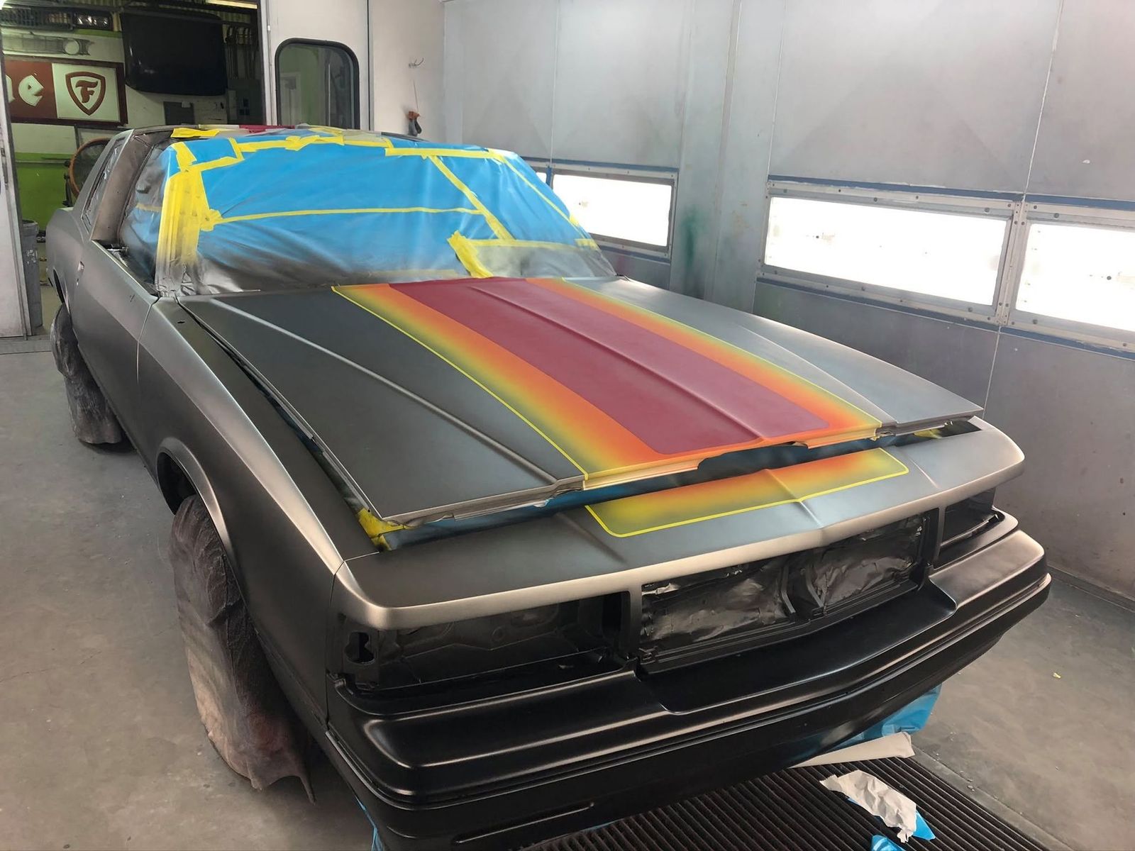 Classic car with retro stripes masked in the paint booth