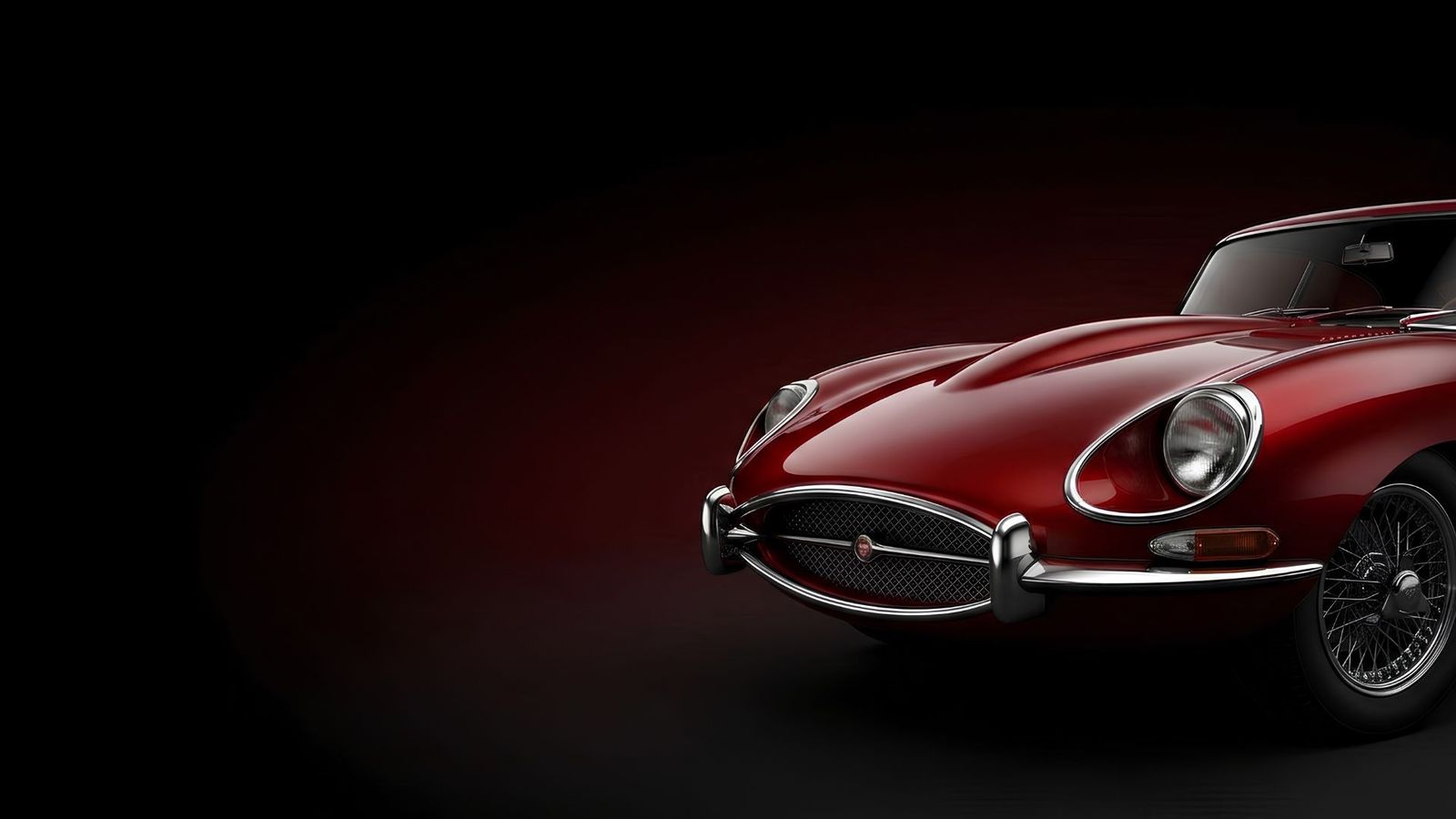 Restored red classic Jaguar E-Type in a dark studio