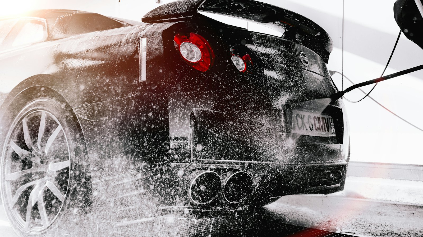 Sports car being rinsed during a full detail