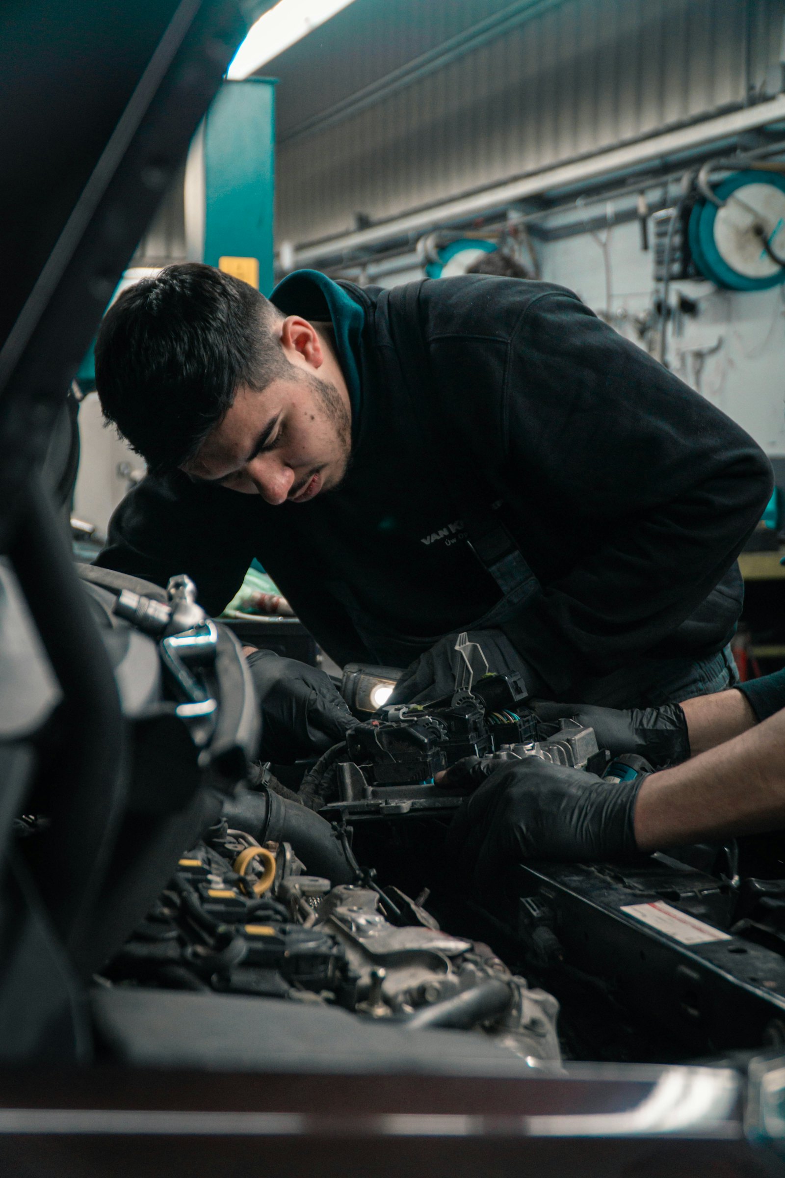 Mechanic leaning under the hood to diagnose an engine