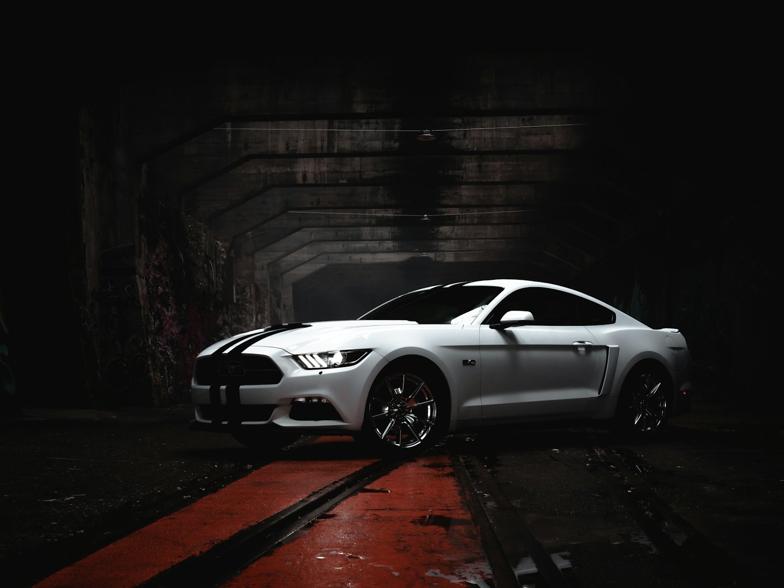 White Ford Mustang in a dark tunnel