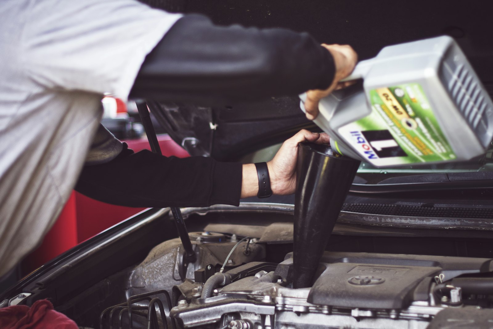 Technician pouring fresh oil into an engine