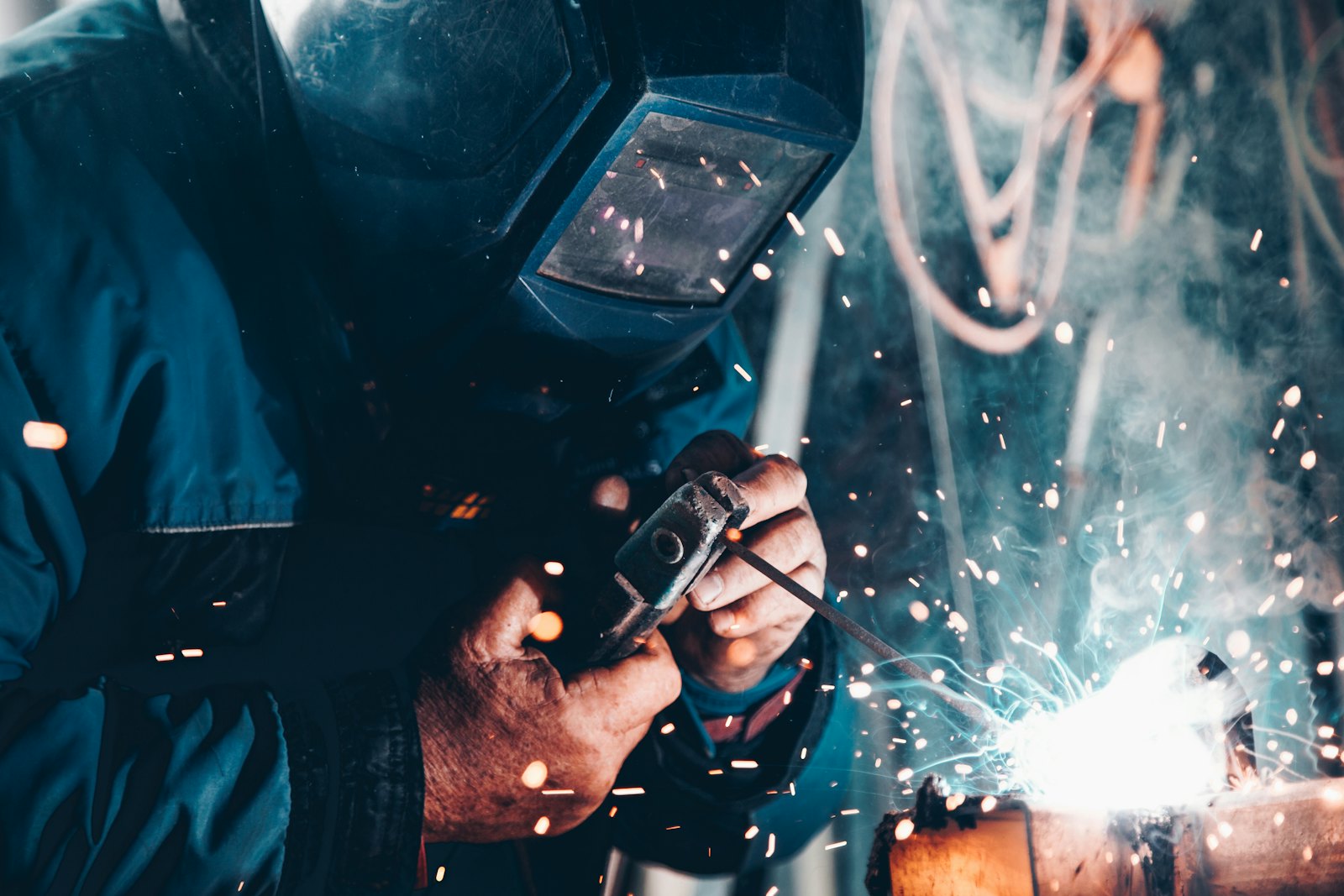 Welder fabricating a custom part in a shower of sparks